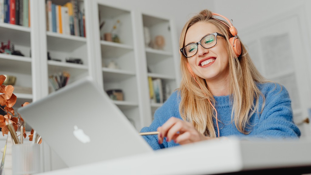 Smiling teacher with headphones teaching online from a bright home office